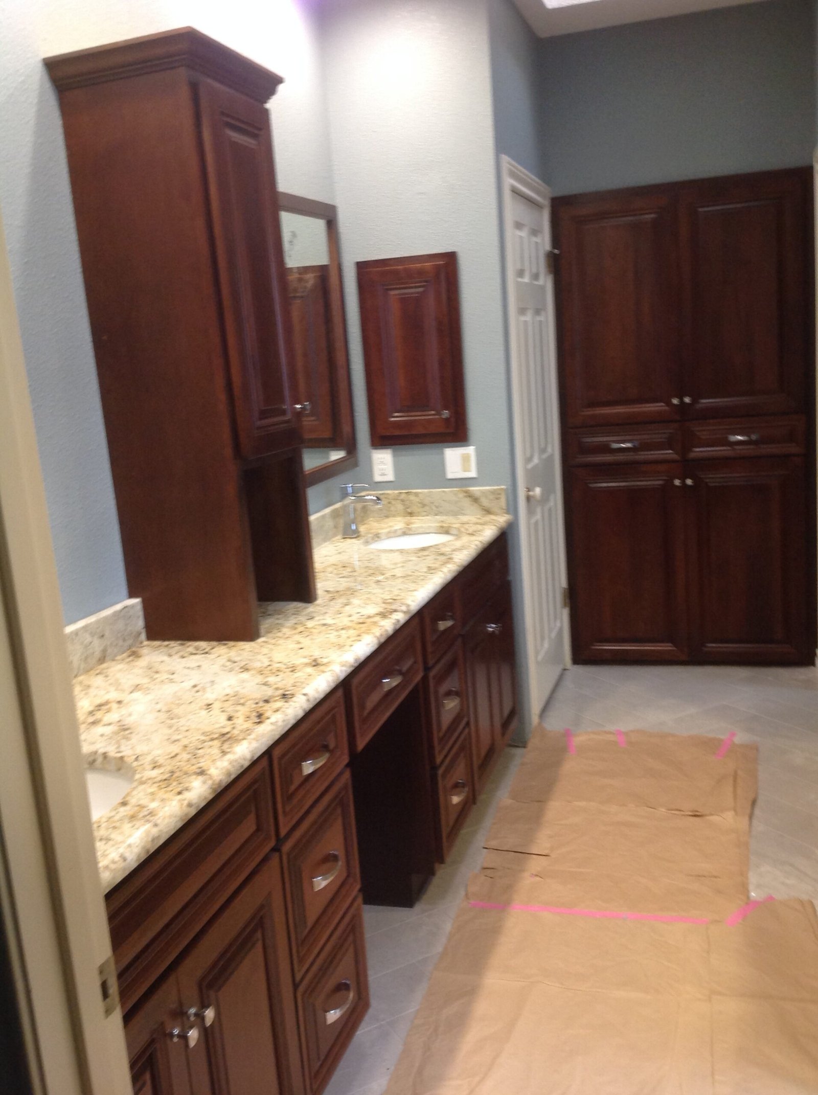 Elegant bathroom vanity cabinets installed beside a bright mirror in a remodeled home