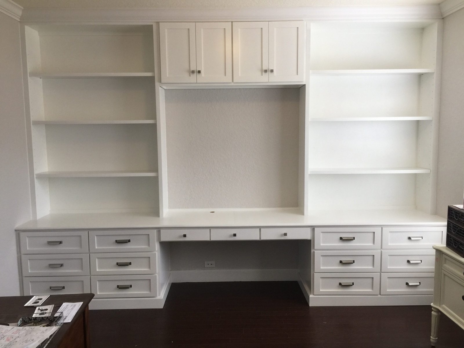 Custom built-in wall unit surrounding television in a bright San Antonio living room