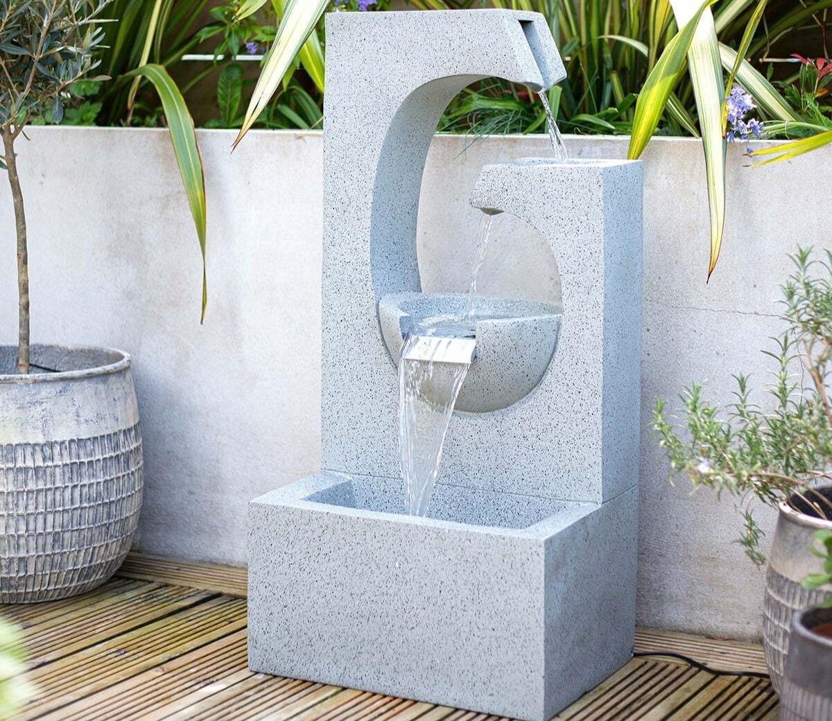 Skilled installer adjusting waterfall stone placement for balanced water flow and appearance