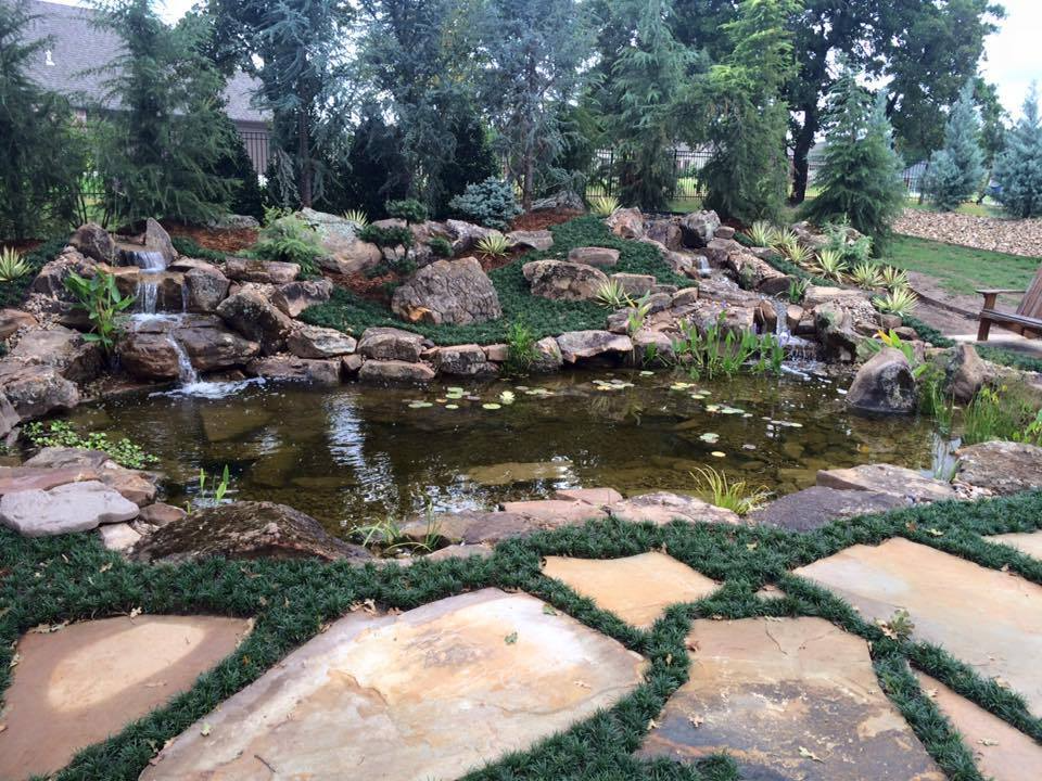 Specialist shaping pond basin and filtration layout with precise landscape construction tools