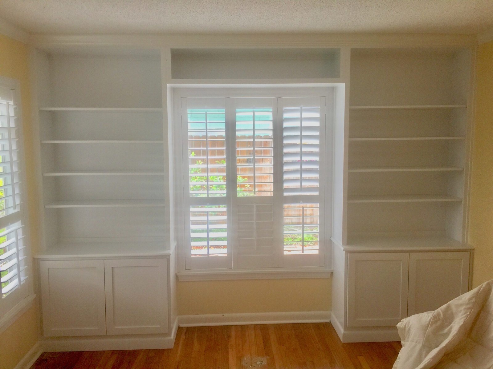 Skilled cabinet specialist measuring and aligning custom shelving for a built-in wall unit