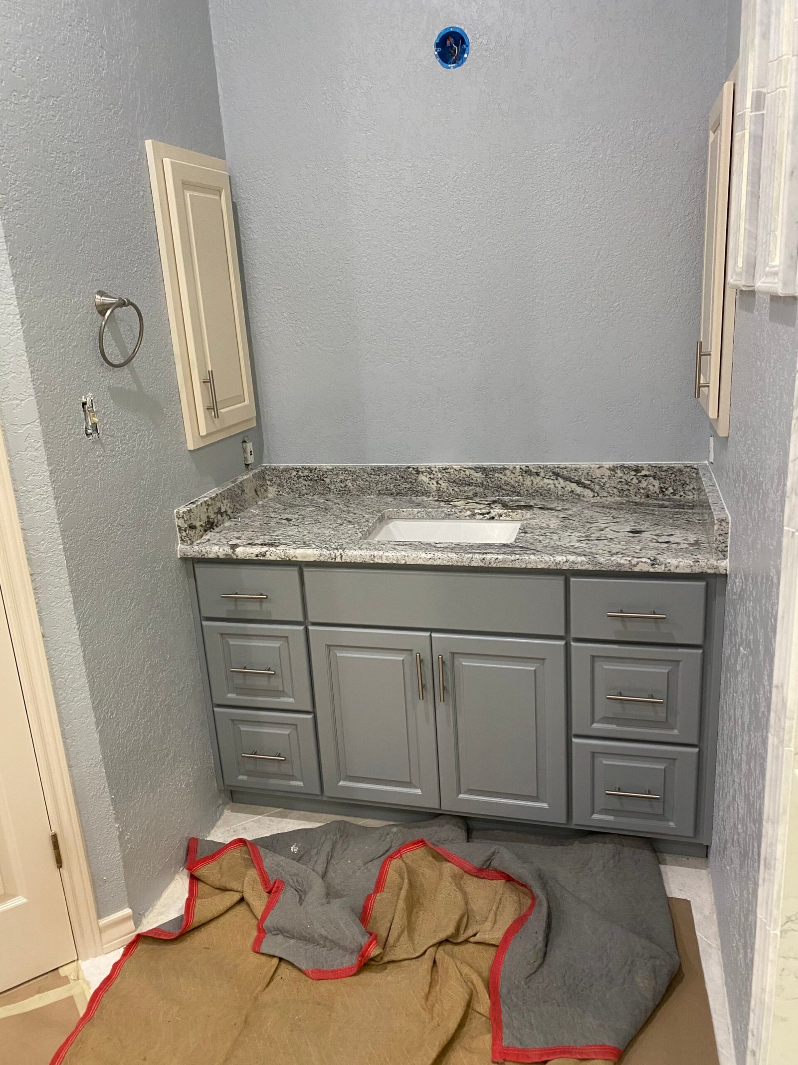 Cabinet expert aligning bathroom vanity doors with careful precision and finishing detail