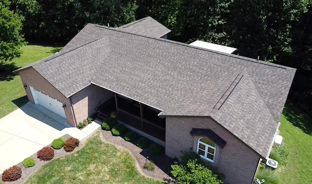 Roof Replacement in Charleston - WV in progress as workers install new shingles across a steep roof